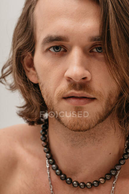 Portrait of a smiling handsome shirtless man wearing necklaces — Stock Photo