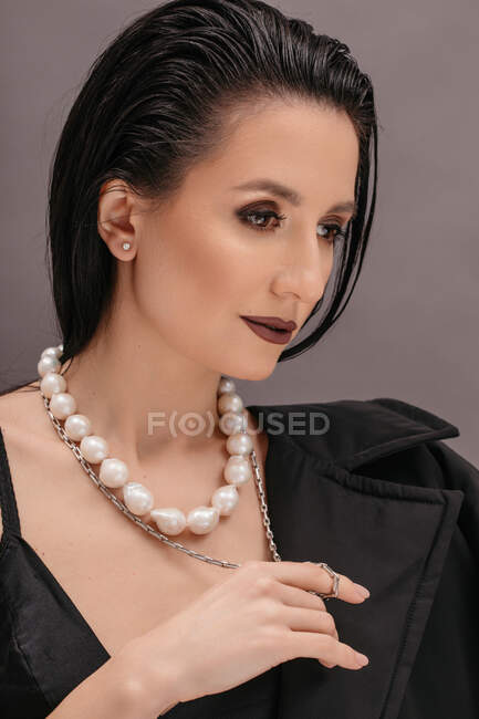Retrato de uma mulher bonita usando um colar de pérolas — Fotografia de Stock