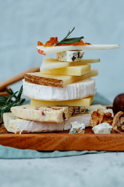 Cheese with nuts and honey on a wooden board — Stock Photo