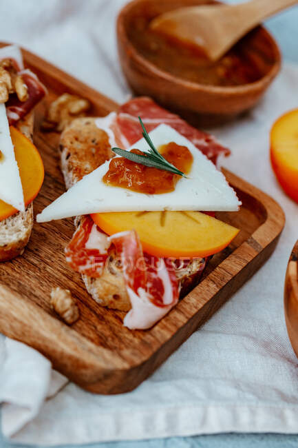 Свежий домашний сыр и тосты с ветчиной, помидорами и медом. селективный фокус. — стоковое фото
