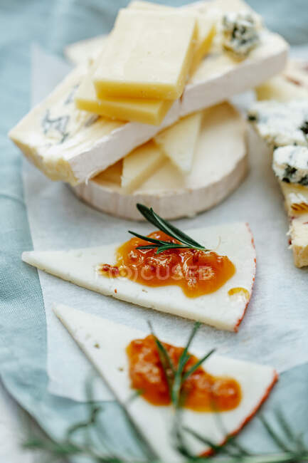 Deliciosos quesos frescos en una mesa con hierbas - foto de stock