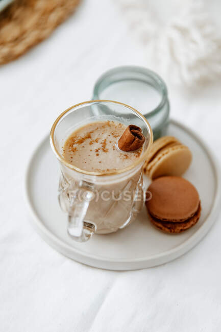 Cup of coffee with croissant, cookies, cinnamon, anise, macaroons, tea on white background, top — Stock Photo