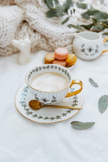 Café en una taza y croissant con malvaviscos sobre un fondo blanco. - foto de stock