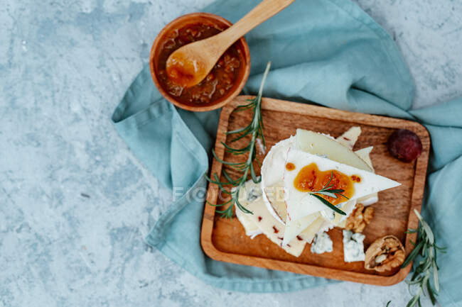 Frühstück mit Käse, Nüssen und Honig auf blauem Hintergrund — Stockfoto