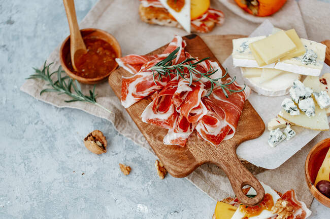 Cheese platter with prosciutto and figs on the cutting board. top view — Stock Photo