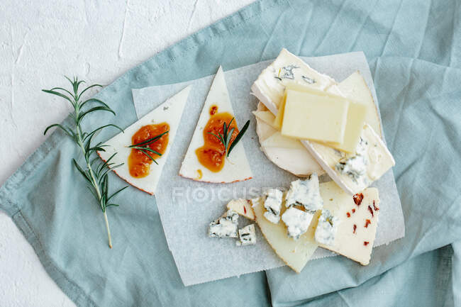 Queso con queso feta y hierbas en una tabla de madera - foto de stock