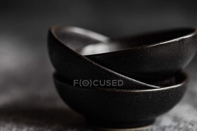 Minimalistic black ceramic bowls on concrete background — Stock Photo