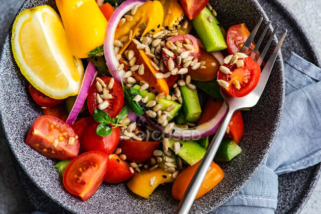 Salade de légumes santé aux herbes et graines servie sur table en béton — Photo de stock