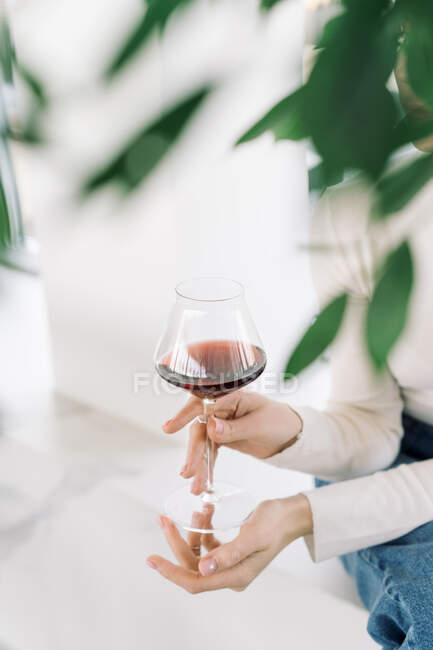 Close-Up de uma mulher desfrutando de um copo de vinho tinto — Fotografia de Stock
