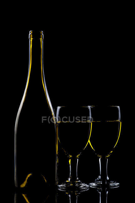 Дві склянки білого вина біля пляшки вина. — стокове фото