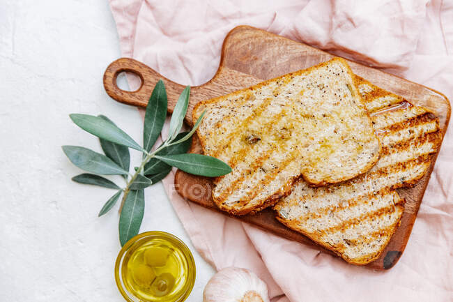 Flat lay ciabatta bread and Olive oil, garlic on white background directly above. — Stock Photo