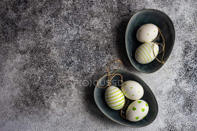 Easter place setting with stone plates and green colored holiday decoration — Stock Photo