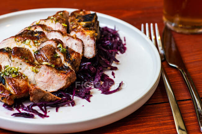 Slices of bbq meat served with salad of red cabbage with craft beer — Stock Photo