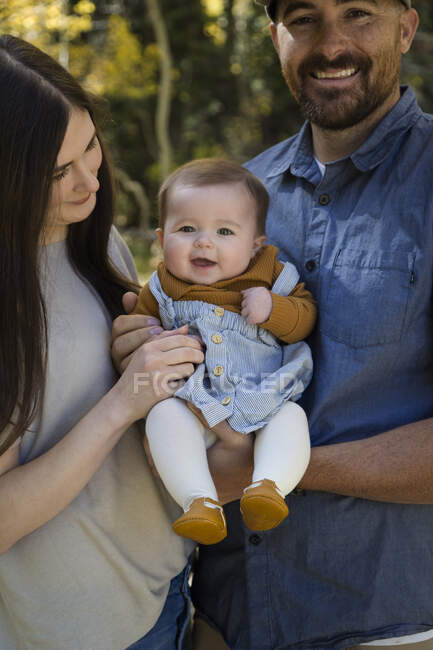 Retrato de um casal feliz em pé na floresta com sua filha bebê, Califórnia, EUA — Fotografia de Stock