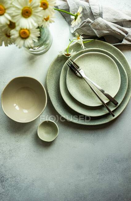 Overhead view of a rustic place setting and vase filled with daisies — Stock Photo