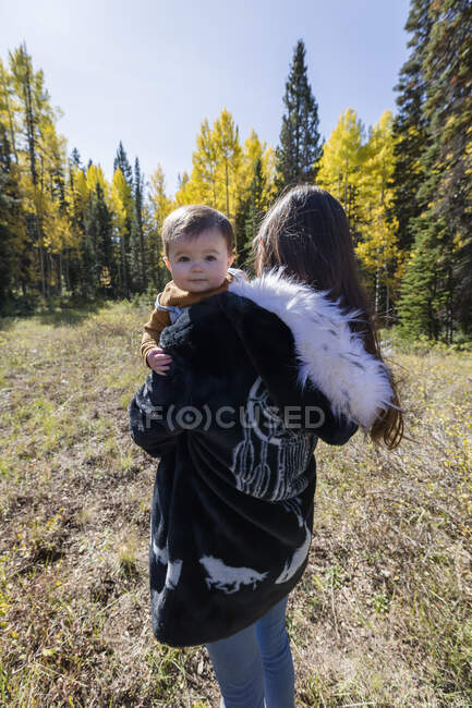 Portrait of a woman standing in forest holding her baby daughter, California, USA — Stock Photo