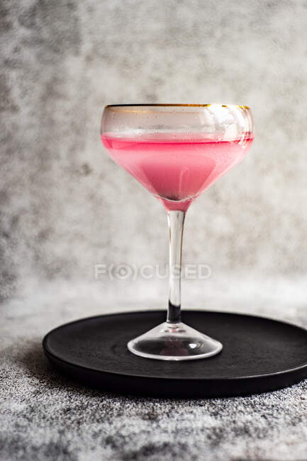 Pink grapefruit gin spritz cocktail served in a glass on sunny day — Stock Photo