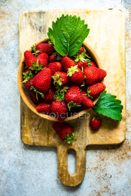 Concept de saine alimentation avec des fraises fraîches crues servies dans un bol sur un fond de béton — Photo de stock