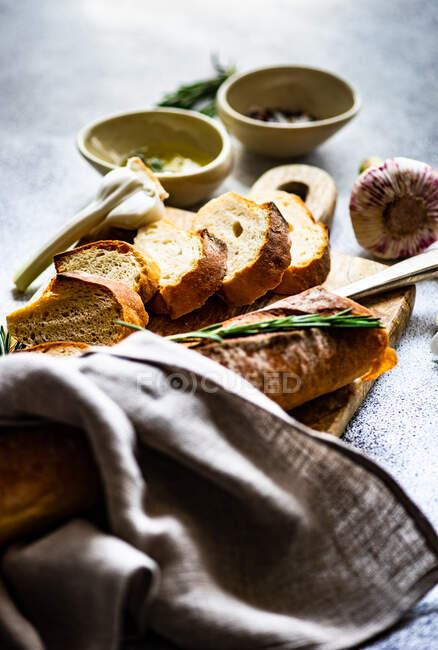Concetto gastronomico con fette di baguette francese e olio d'oliva su fondo di cemento — Foto stock