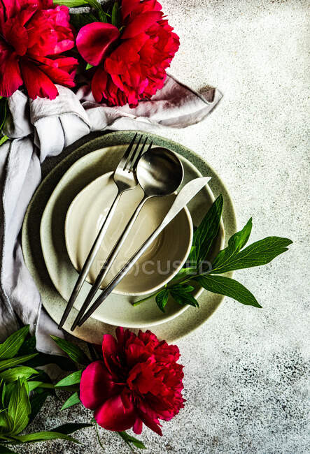 Summer background with place setting decorated with bright red peony flowers — Stock Photo