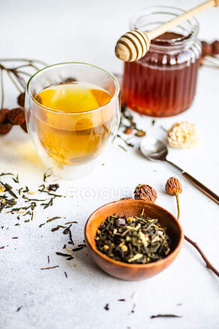Concept de thé floral avec feuilles de thé sur fond de béton — Photo de stock