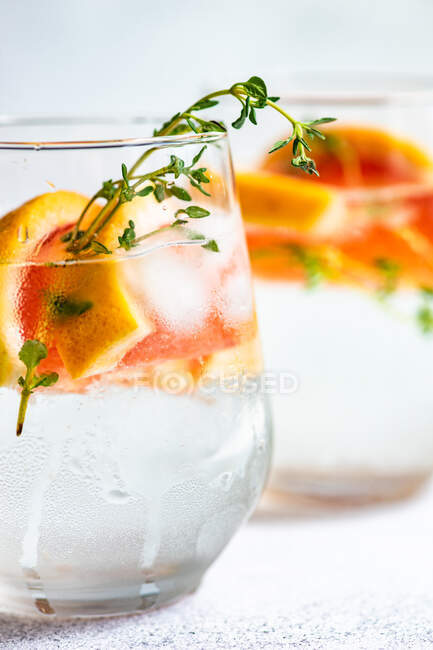 Cóctel de verano con pomelo y tomillo como concepto de fondo de verano - foto de stock