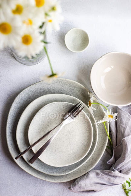 Summer place setting with white daisy flowers on concrete table — Stock Photo
