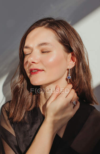 Portrait of a beautiful woman with her hand on her neck — Stock Photo