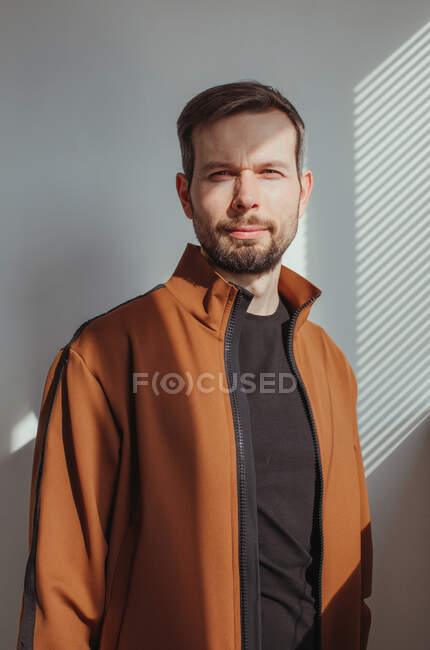Portrait of a handsome man with a beard standing in sunlight — Stock Photo