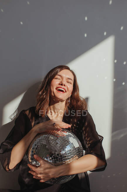 Портрет смеющейся женщины, держащей блестящий шар — стоковое фото