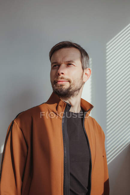 Portrait of a handsome man with a beard standing in sunlight — Stock Photo