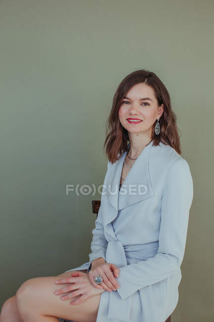 Portrait of a beautiful smiling woman sitting on a chair — Stock Photo