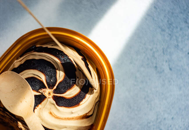 Caja con helado de chocolate y vainilla ya comido en una mesa - foto de stock