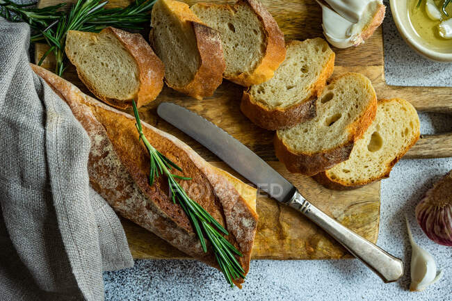 Concept alimentaire avec tranches de baguette française et huile d'olive sur fond de béton — Photo de stock