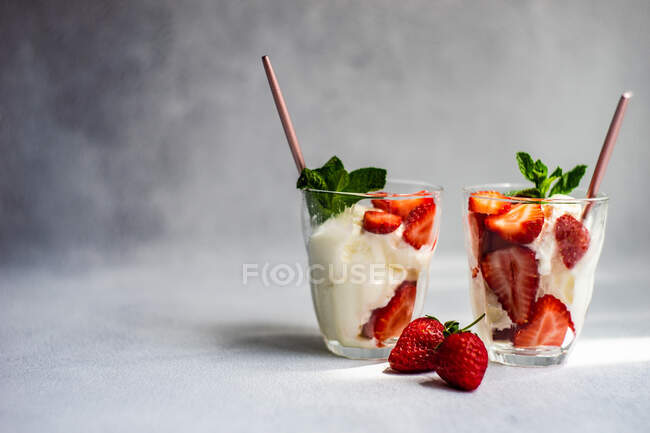 Postre de helado de verano servido con fresas y menta - foto de stock