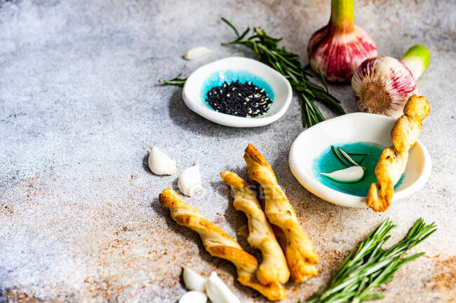 Grissini bastoncini e olio d'oliva con rosmarino fresco servito sul piatto — Foto stock