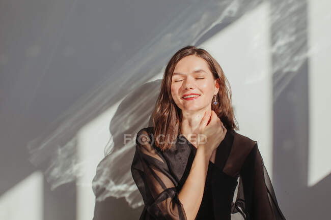 Ritratto di una bella donna felice con la mano sul collo — Foto stock