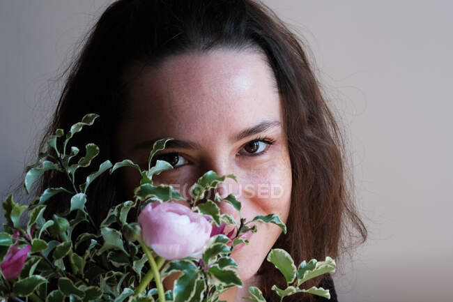 Retrato de uma mulher sorridente segurando um monte de flores na frente de seu rosto — Fotografia de Stock