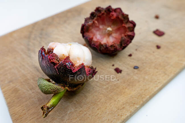 Close-up of an open lychee fruit on a wooden chopping board — Stock Photo