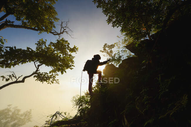 Silhouette di una donna che si arrampica su una montagna, Thailandia — Foto stock