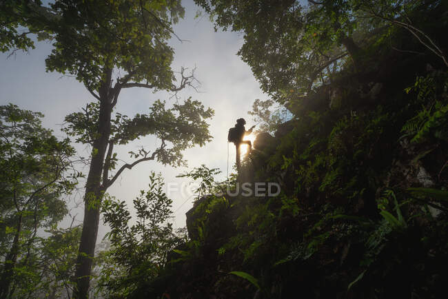 Silhouette of a woman climbing up a mountain, Thailand — Stock Photo