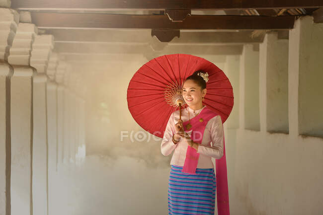 Ritratto di una donna in abiti tradizionali thailandesi con un ombrellone in mano, Thailandia — Foto stock