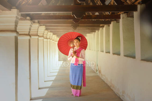 Portrait of a woman in traditional Thai clothing holding a parasol, Thailand — Stock Photo