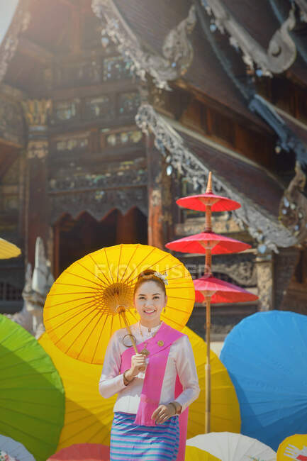 Portrait of a woman in traditional Thai clothing holding a parasol, Thailand — Stock Photo