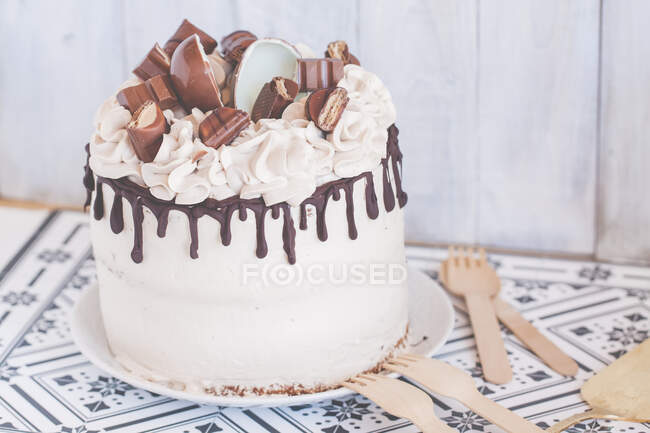 Шоколадний торт з вершковим кремом прикрашений різноманітними шоколадними цукерками — стокове фото