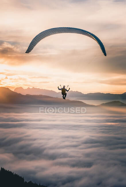 Man Paragliding above the clouds at sunset, Salzburg, Áustria — Fotografia de Stock