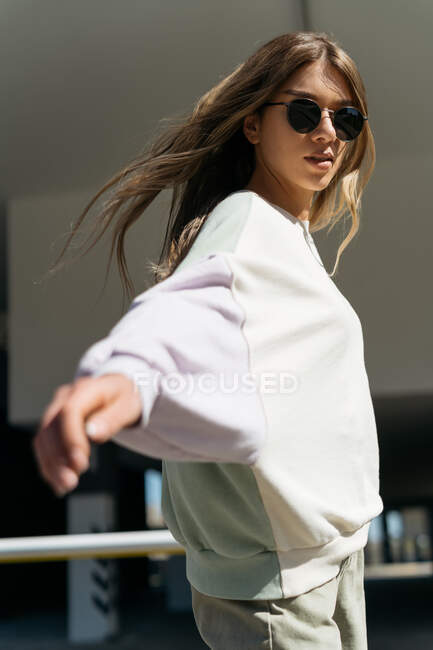 Portrait d'une belle femme en lunettes de soleil marchant dans la rue — Photo de stock