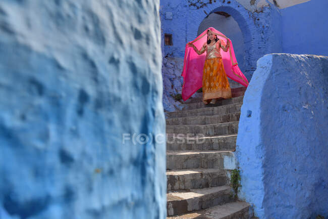 Donna in abiti tradizionali scendendo le scale, Chefchaouen, Marocco — Foto stock