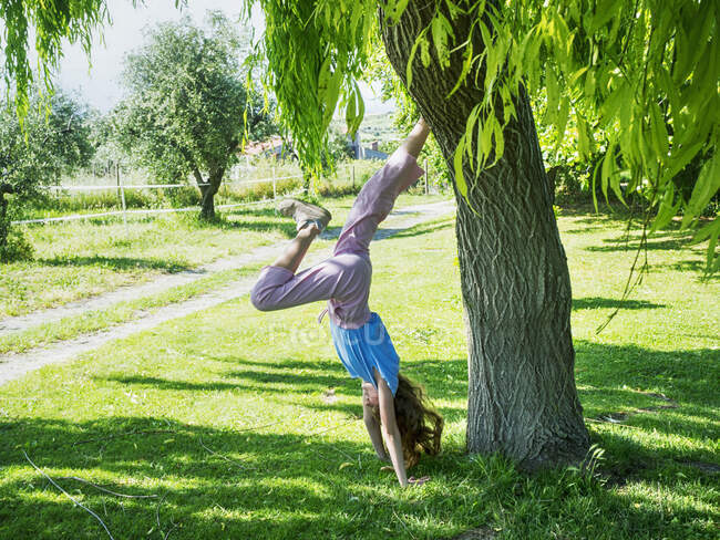 Menina fazendo um suporte de mão no parque, Itália — Fotografia de Stock