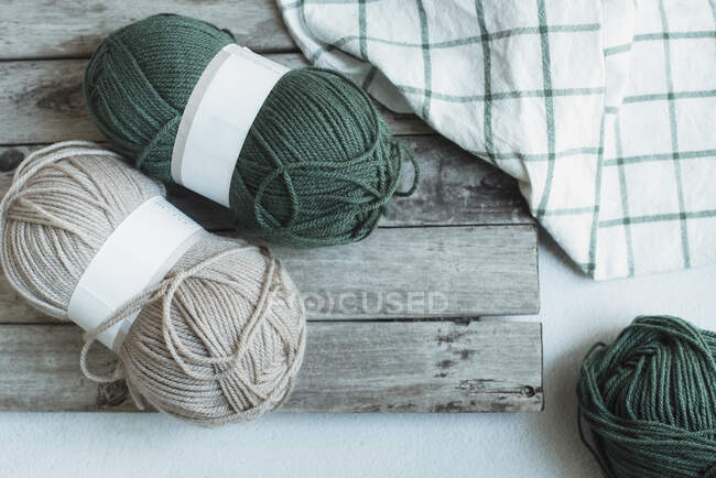 Skeins of wool threads on wooden board, top view — Stock Photo